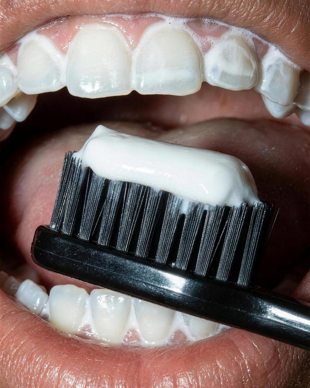 Fluoride-free nHA toothpaste on a black brush, close-up